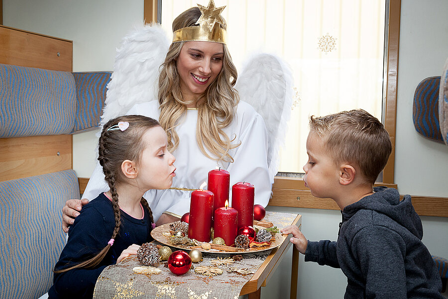 Christkind überrascht Kinder im Zug