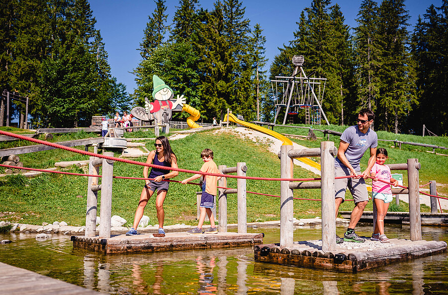 Familie auf einem Floss im Wasser auf der Bürgeralpe.