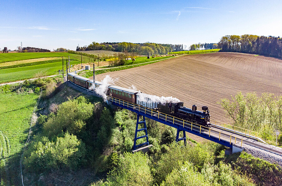 Steam train crosses a bridge