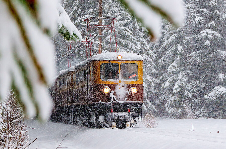 ZUg fährt durch verschneite Landschaft