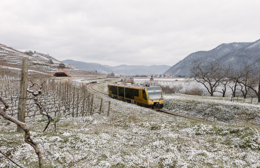 KI generiertes Bild mit gelber Bahn in winterlicher Landschaft