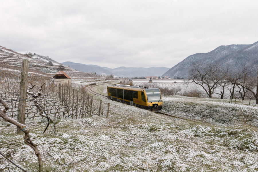 KI generiertes Bild mit gelber Bahn in winterlicher Landschaft