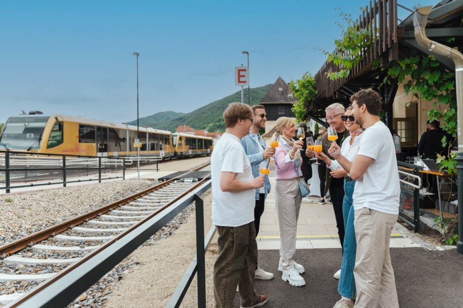 Menschen, die am Bahnsteig lachen und trinken
