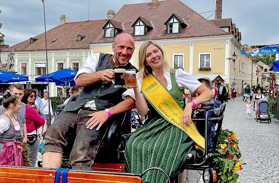 Mann und Frau in Tracht auf einer Kutsche in der Altstadt