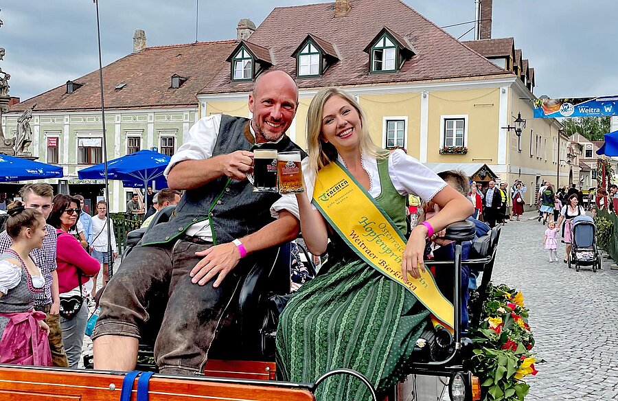 Mann und Frau in Tracht auf einer Kutsche in der Altstadt